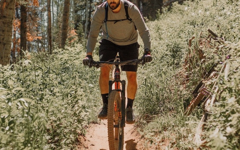 A beautiful community at the heart of all your passions a guy riding a bike in the mountain trails
