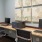 a desk with a computer and a map on the wall